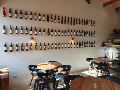 Lahve od vína připevněné na zdi ve spolkové vinotéce Dunajovských kopců Korek v Mikulově. 